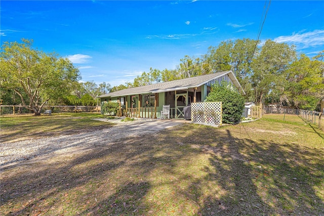 view of front of home with a porch, a front yard, and fence