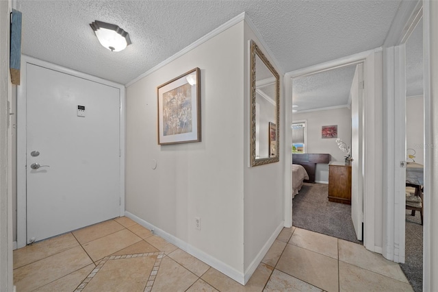 tiled foyer with ornamental molding and a textured ceiling