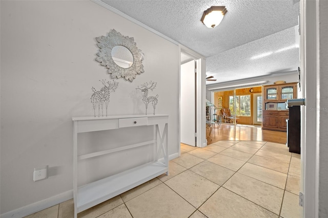 hallway with light tile patterned flooring and a textured ceiling