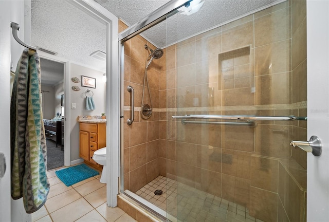 bathroom featuring tile patterned flooring, vanity, a shower with door, and toilet