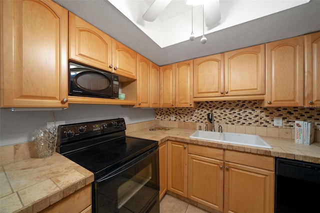 kitchen featuring sink, backsplash, light tile patterned floors, black appliances, and light brown cabinets