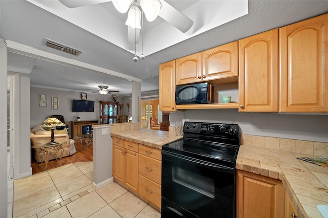 kitchen with light tile patterned flooring, light brown cabinetry, tile counters, ceiling fan, and black appliances