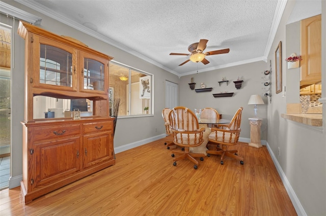 dining room with ornamental molding, light wood-type flooring, ceiling fan, and a textured ceiling