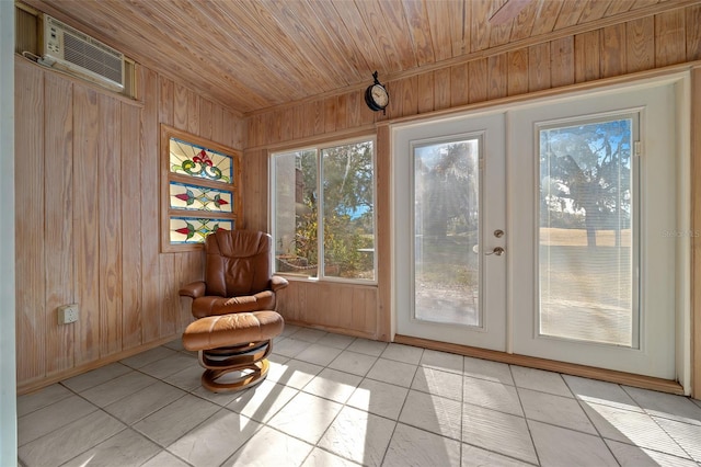 unfurnished room with wood walls, a wall mounted air conditioner, light tile patterned floors, and wooden ceiling