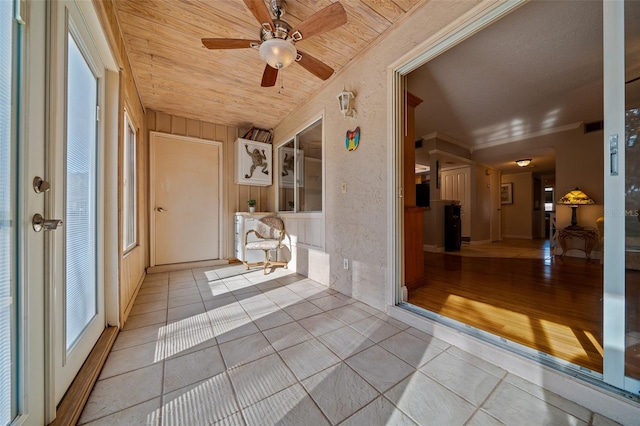 unfurnished sunroom featuring ceiling fan and wooden ceiling