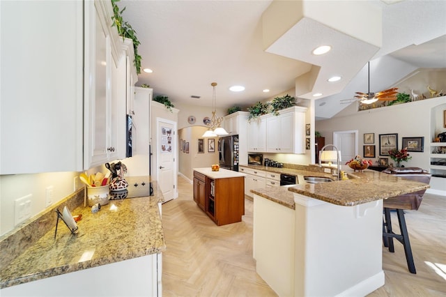 kitchen featuring black appliances, sink, white cabinets, kitchen peninsula, and light parquet flooring