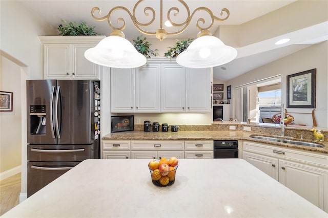 kitchen featuring stainless steel refrigerator with ice dispenser, decorative light fixtures, sink, and white cabinets