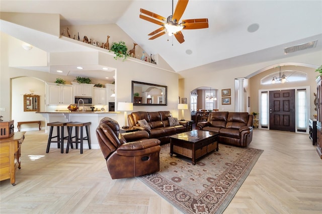 living room with ceiling fan, high vaulted ceiling, and light parquet flooring