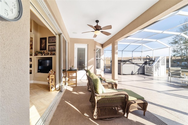 view of patio with ceiling fan and a lanai