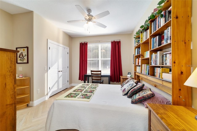 bedroom with ceiling fan, a closet, and light parquet floors