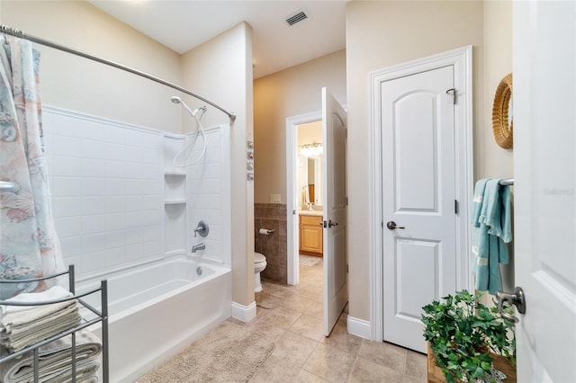 full bathroom with shower / bathing tub combination, tile walls, vanity, toilet, and tile patterned floors