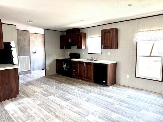 kitchen with dark brown cabinetry, sink, light wood-type flooring, and black appliances