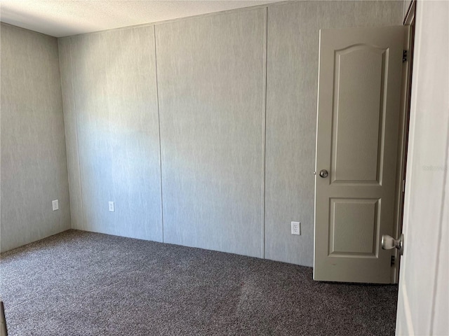 empty room featuring dark carpet