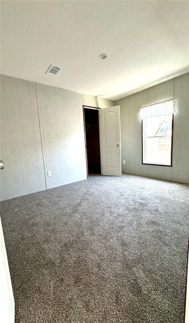 spare room with carpet floors and a textured ceiling