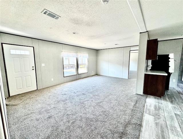 unfurnished living room featuring carpet floors and a textured ceiling