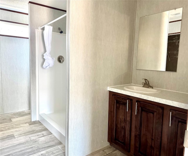 bathroom featuring hardwood / wood-style flooring, vanity, and curtained shower