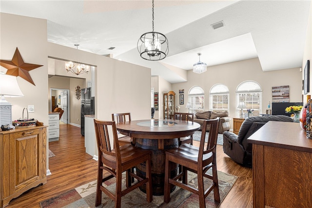 dining room with dark hardwood / wood-style flooring and a chandelier