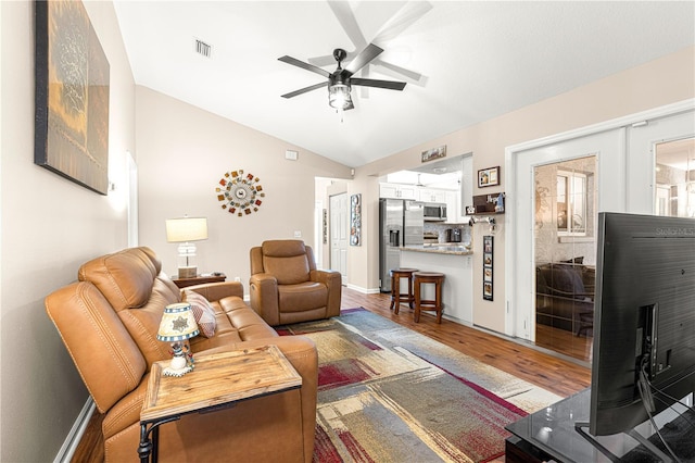 living room featuring lofted ceiling, wood-type flooring, and ceiling fan