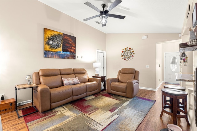 living room featuring hardwood / wood-style flooring, vaulted ceiling, and ceiling fan