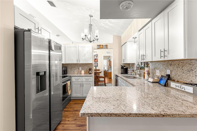 kitchen featuring sink, white cabinetry, hanging light fixtures, appliances with stainless steel finishes, and kitchen peninsula