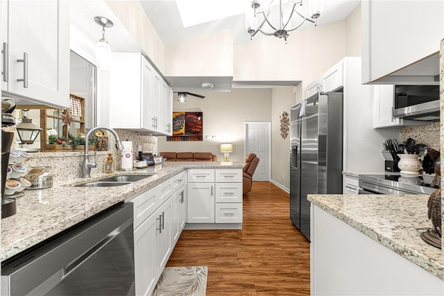 kitchen with dark hardwood / wood-style floors, white cabinetry, sink, hanging light fixtures, and stainless steel appliances