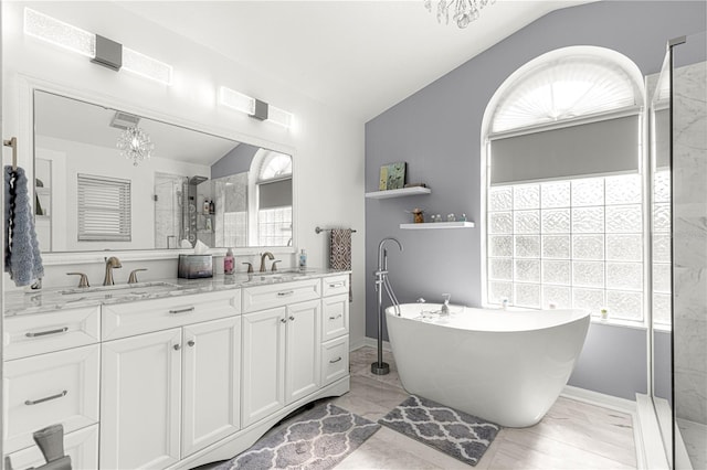 bathroom with vanity, vaulted ceiling, shower with separate bathtub, and a chandelier