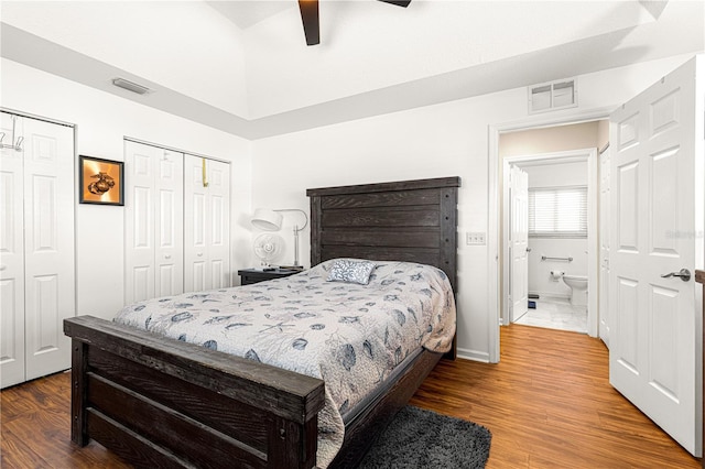 bedroom featuring multiple closets, wood-type flooring, and ceiling fan