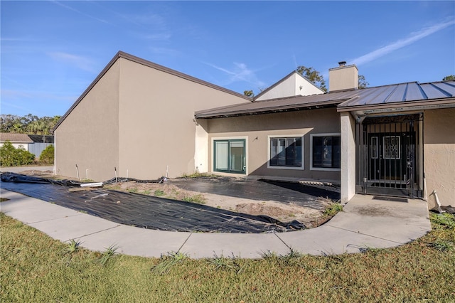 back of property featuring a yard and a patio