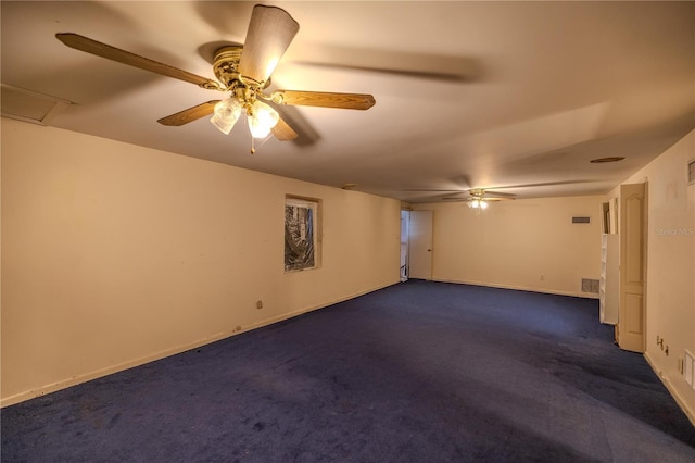 spare room featuring dark carpet and ceiling fan