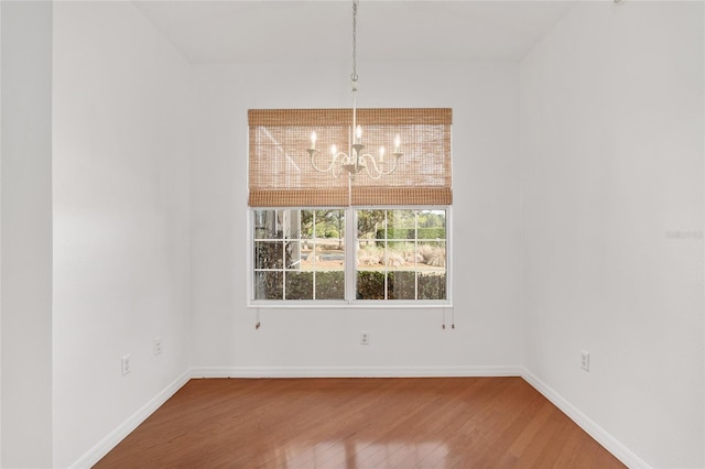 unfurnished dining area featuring wood-type flooring and a chandelier