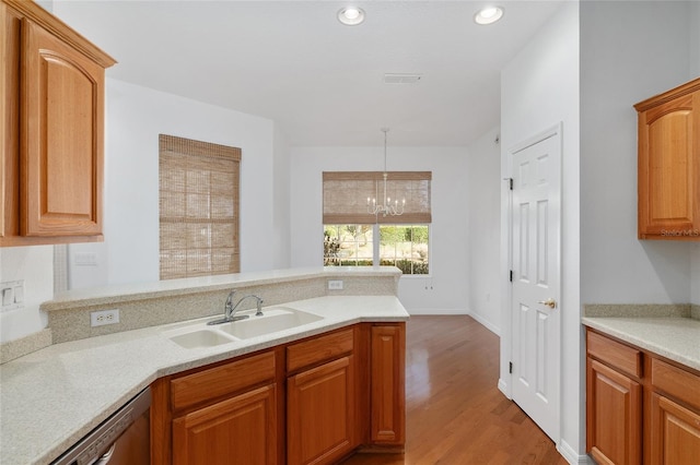 kitchen featuring sink, a chandelier, dishwasher, pendant lighting, and light hardwood / wood-style floors