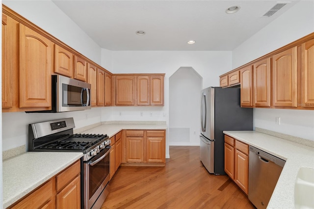 kitchen with light wood-type flooring and appliances with stainless steel finishes