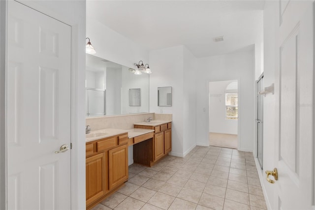 bathroom featuring a shower with door, vanity, and tile patterned flooring