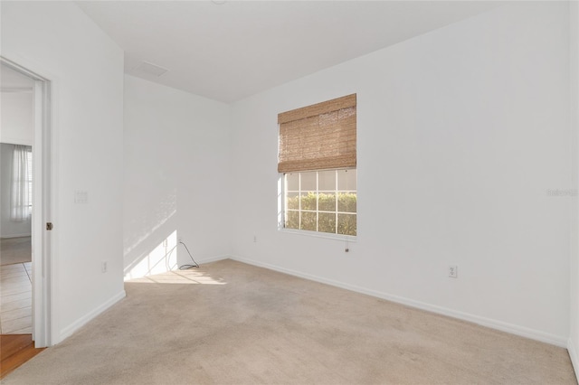 unfurnished room featuring light carpet