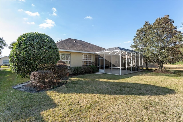 back of property with a yard and glass enclosure