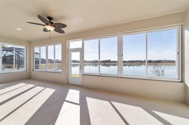 unfurnished sunroom with a water view and ceiling fan