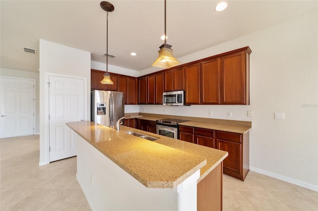 kitchen featuring appliances with stainless steel finishes, a kitchen island with sink, sink, and pendant lighting