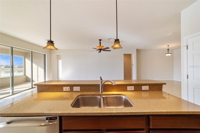 kitchen with sink, light stone counters, stainless steel dishwasher, pendant lighting, and ceiling fan