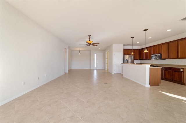 kitchen featuring appliances with stainless steel finishes, a center island, pendant lighting, and ceiling fan