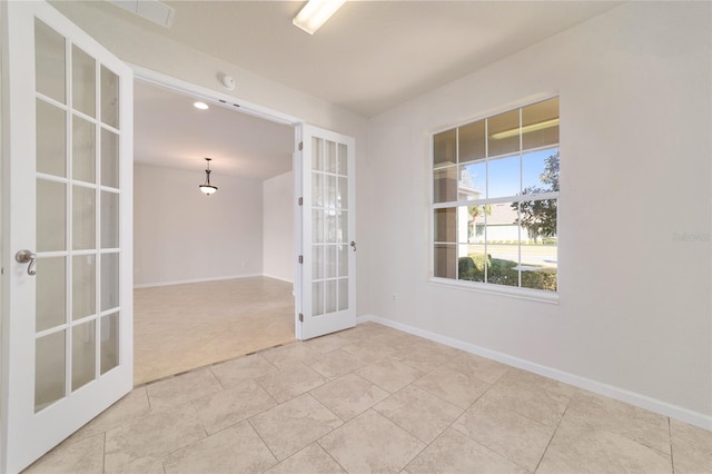 unfurnished room featuring french doors