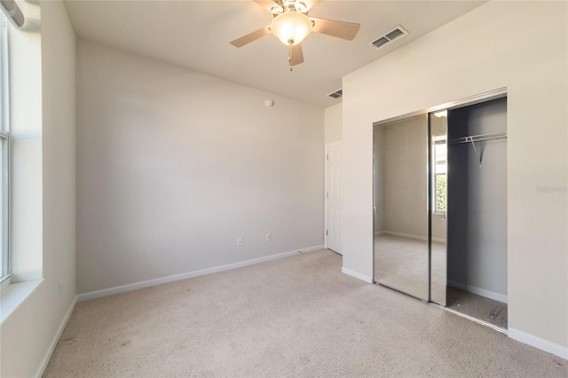 unfurnished bedroom with light carpet, a closet, and ceiling fan