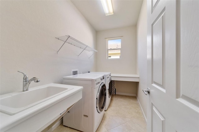 washroom featuring sink, light tile patterned floors, and washer and clothes dryer