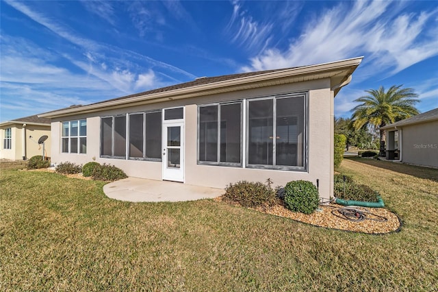 rear view of house with a patio and a lawn