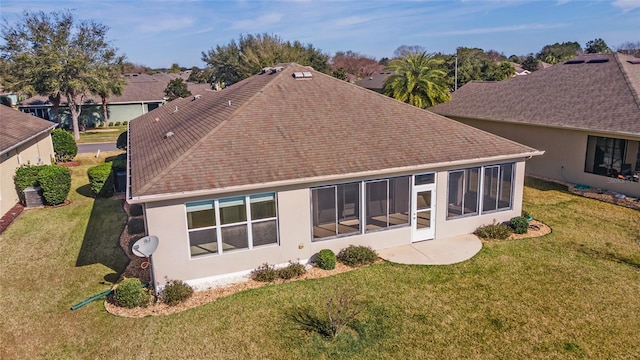 back of property featuring a yard and a sunroom