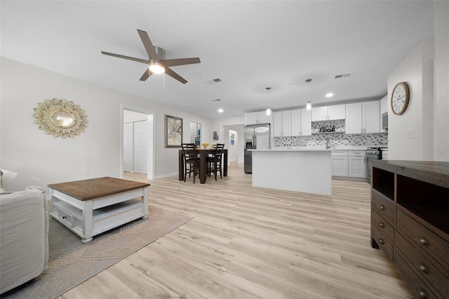 living room with ceiling fan and light hardwood / wood-style floors