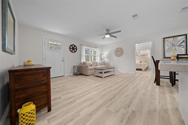 living room featuring ceiling fan and light hardwood / wood-style floors