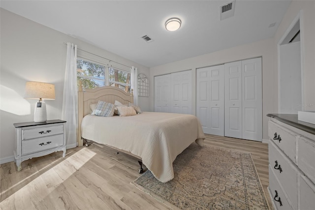 bedroom featuring two closets and light wood-type flooring