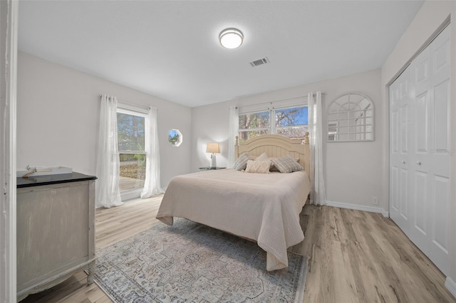 bedroom with light wood-type flooring and a closet