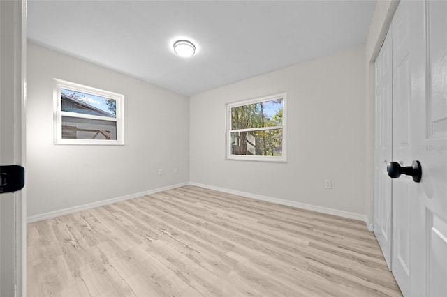 unfurnished bedroom featuring a closet and light wood-type flooring