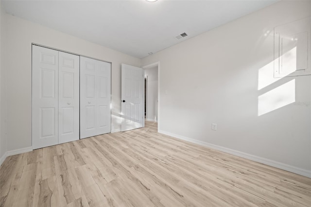 unfurnished bedroom with a closet and light hardwood / wood-style flooring